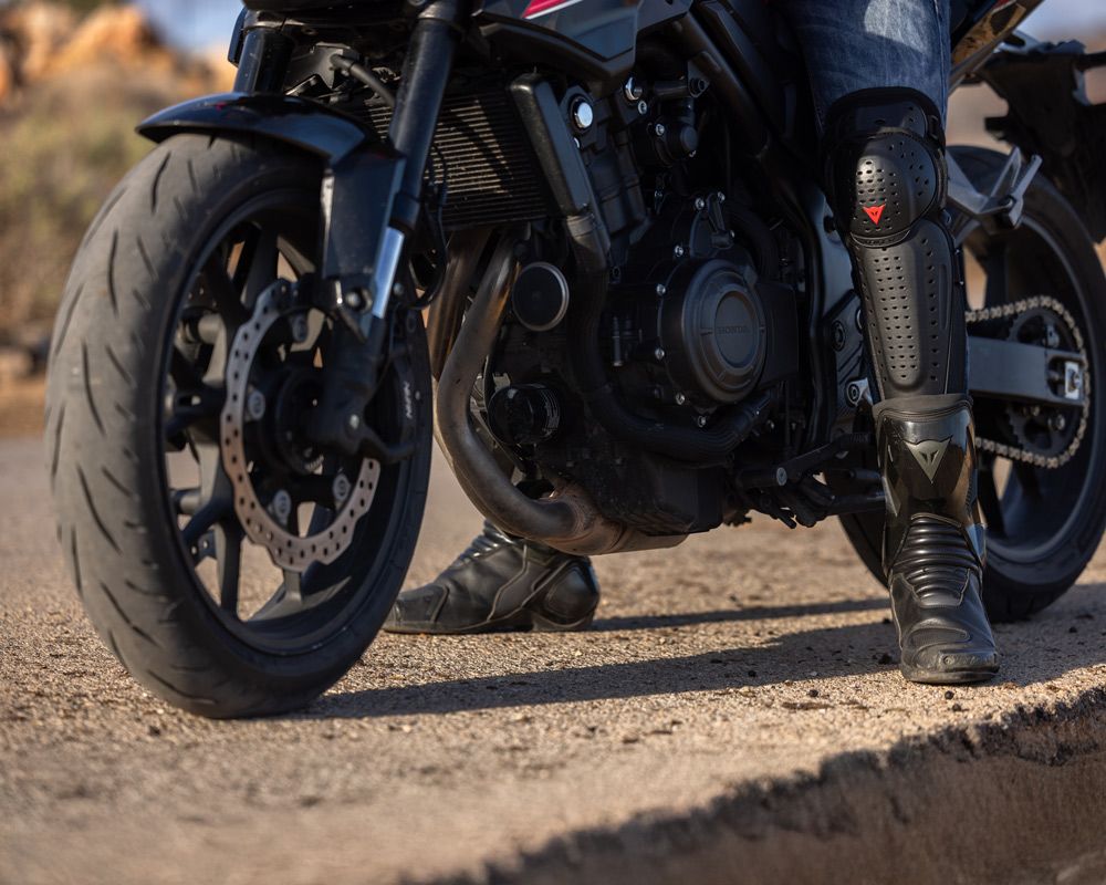 Κοντινό στα πόδια και στα προστατευτικά του Μιχάλη με μπότες και επιγονατίδες Dainese – Gas Rider Stories #5